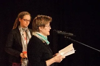 Ellen Widmaier en Bianca in de spotlights op het podium, Ellen Widmaier leest voor uit de bundel