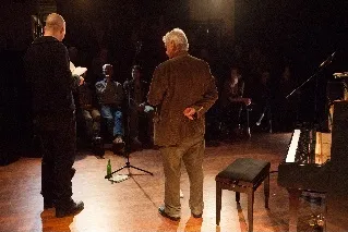 Tsea Bruinja en Ralf Thenior op de rug gezien op het podium, Tsea Bruinja leest voor